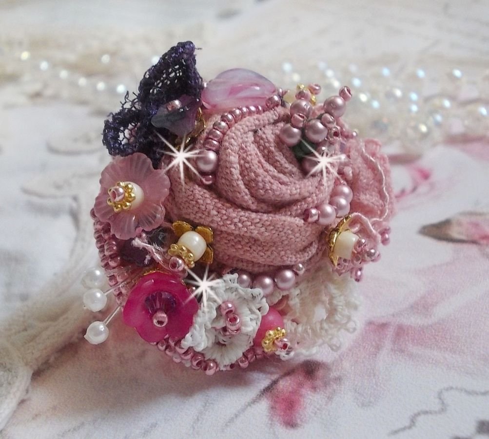 Poetic Garden Ring broderad med linne, fina spetsar, Swarovski-kristaller, pärlemorblad, Lucite-blommor, glaspärlor och fröpärlor. 