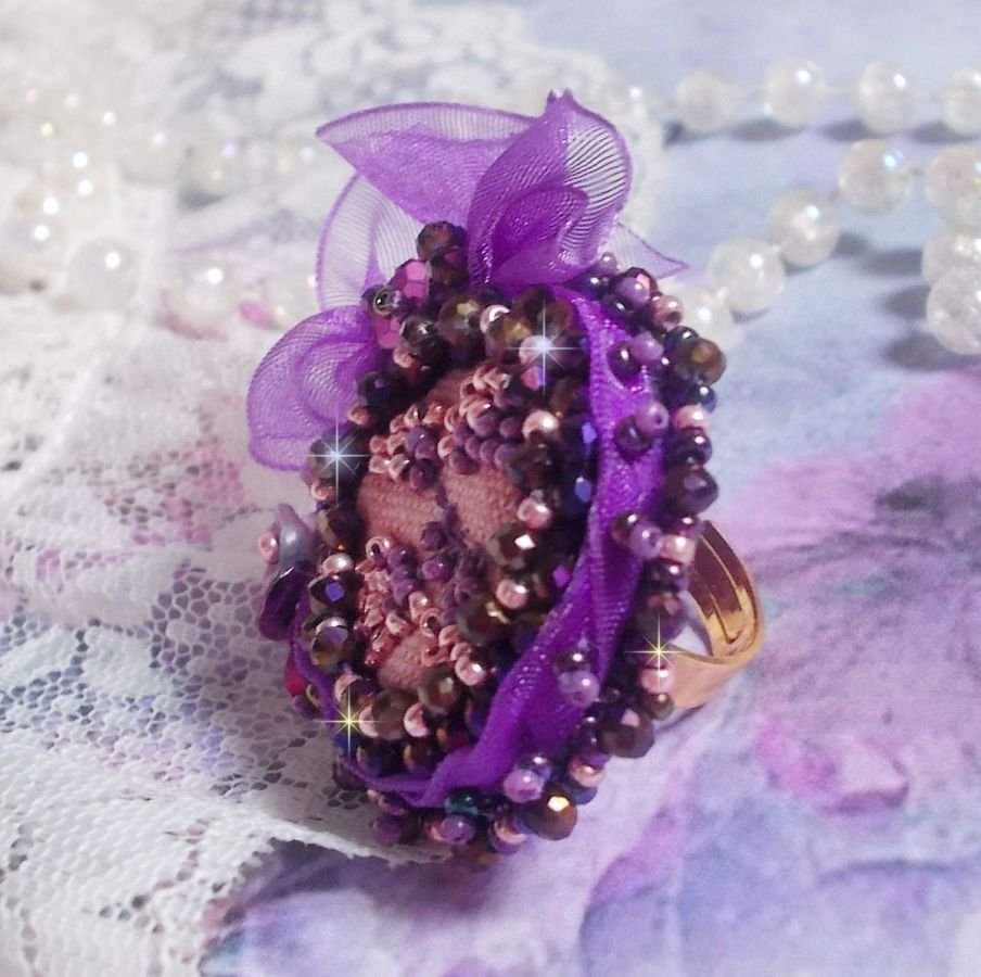 Romantisk Lady Ring broderad på ett rosa linnetyg med rosa, iris, lila och persika pärlor. 