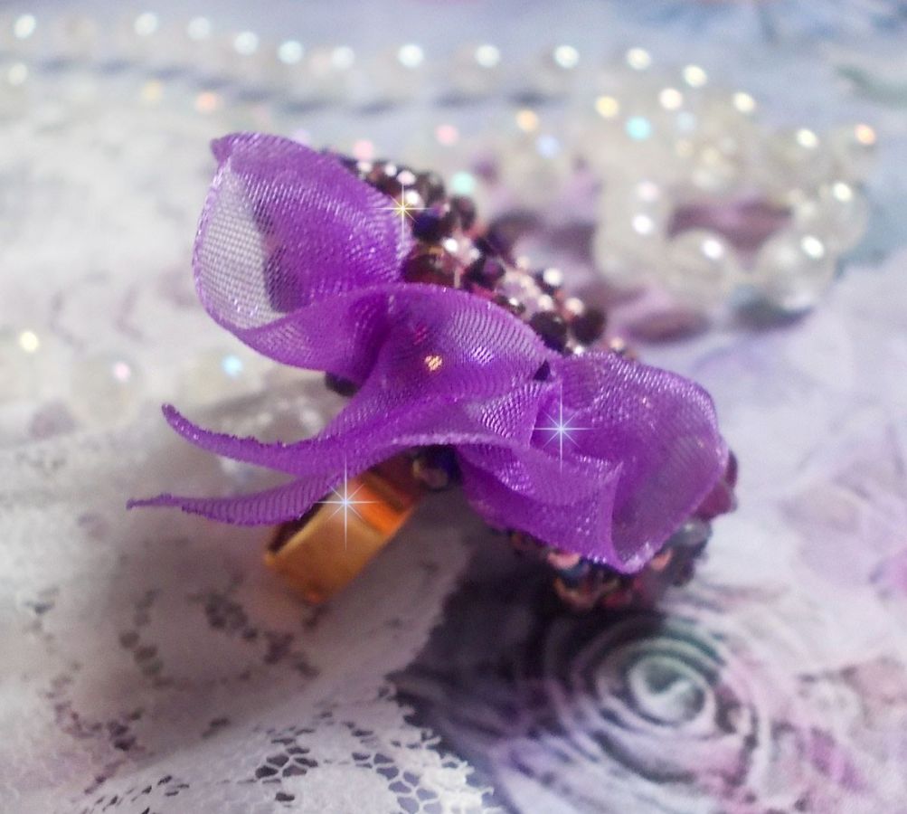 Romantisk Lady Ring broderad på ett rosa linnetyg med rosa, iris, lila och persika pärlor. 