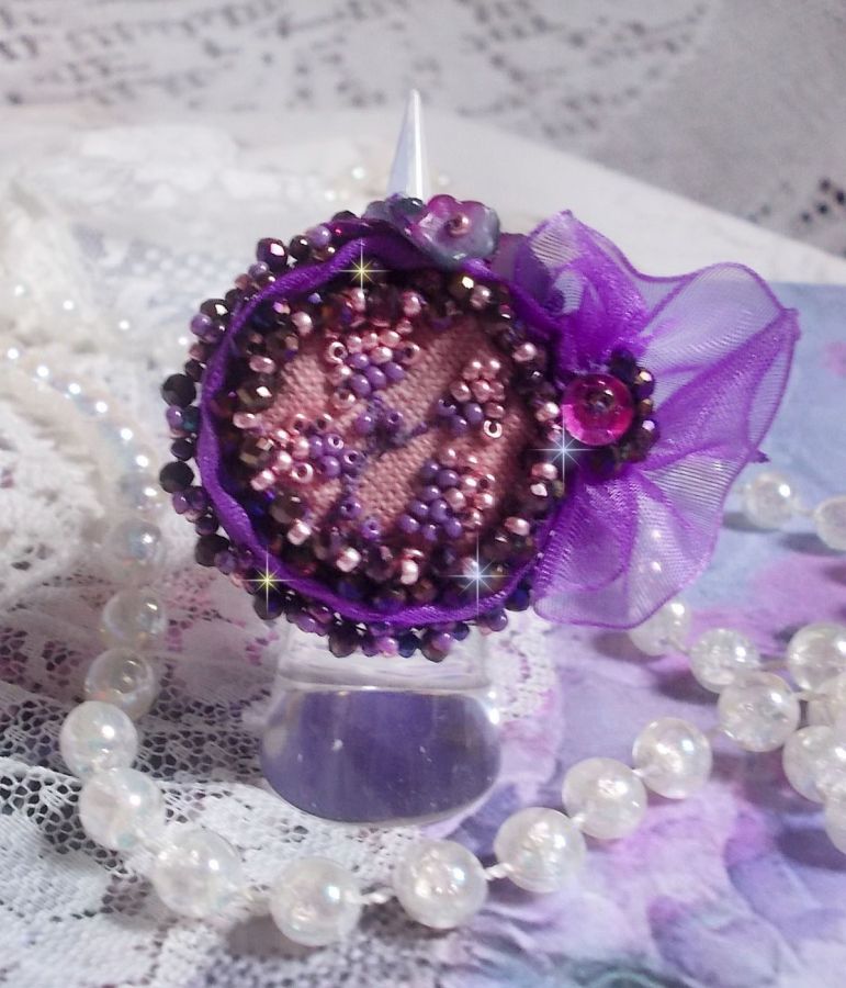 Romantisk Lady Ring broderad på ett rosa linnetyg med rosa, iris, lila och persika pärlor. 