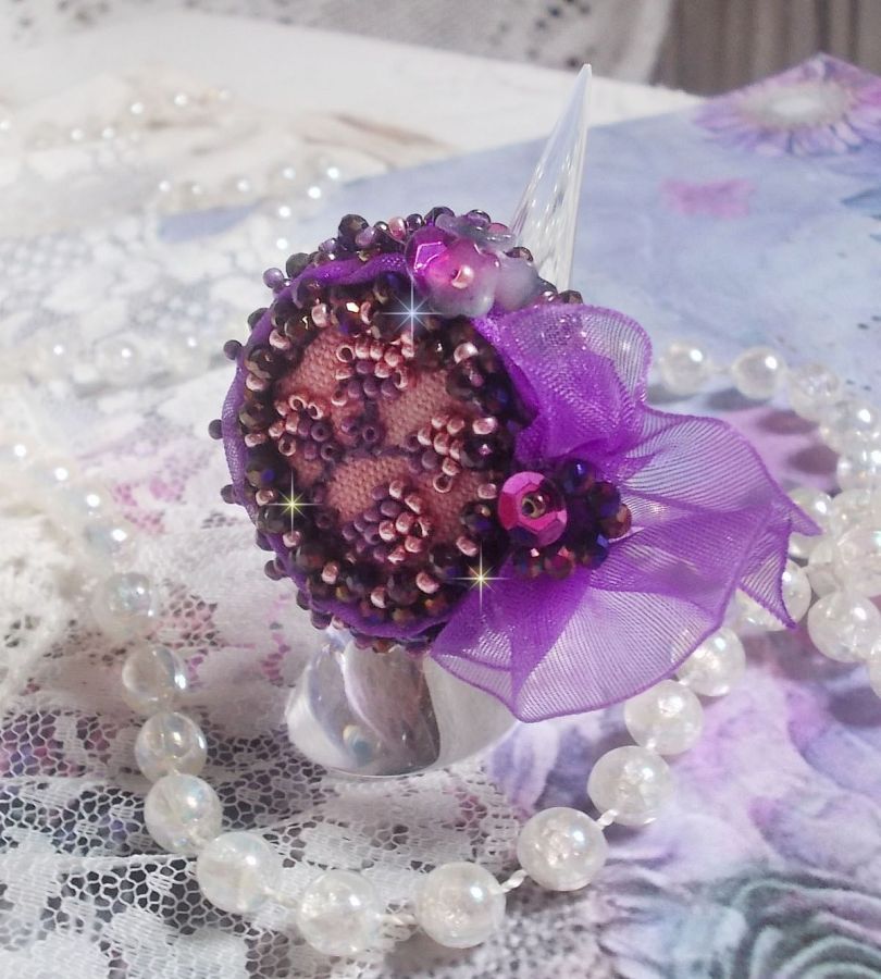 Romantisk Lady Ring broderad på ett rosa linnetyg med rosa, iris, lila och persika pärlor. 