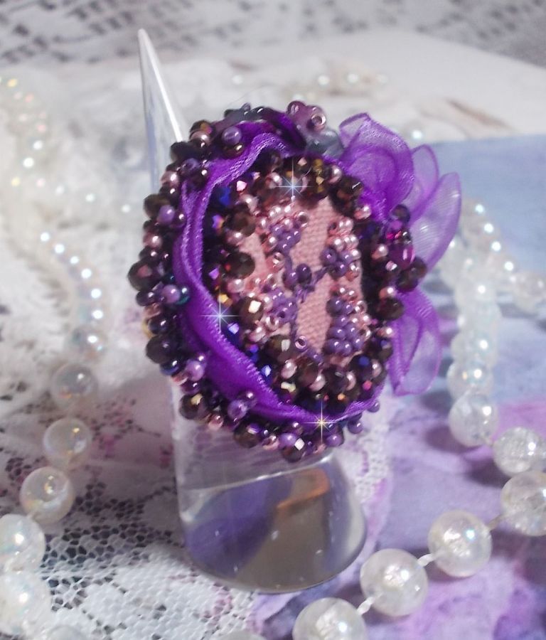 Romantisk Lady Ring broderad på ett rosa linnetyg med rosa, iris, lila och persika pärlor. 