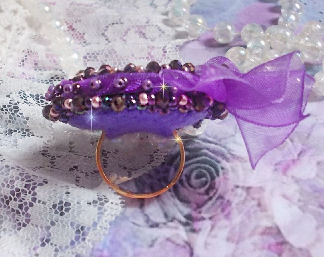 Romantisk Lady Ring broderad på ett rosa linnetyg med rosa, iris, lila och persika pärlor. 