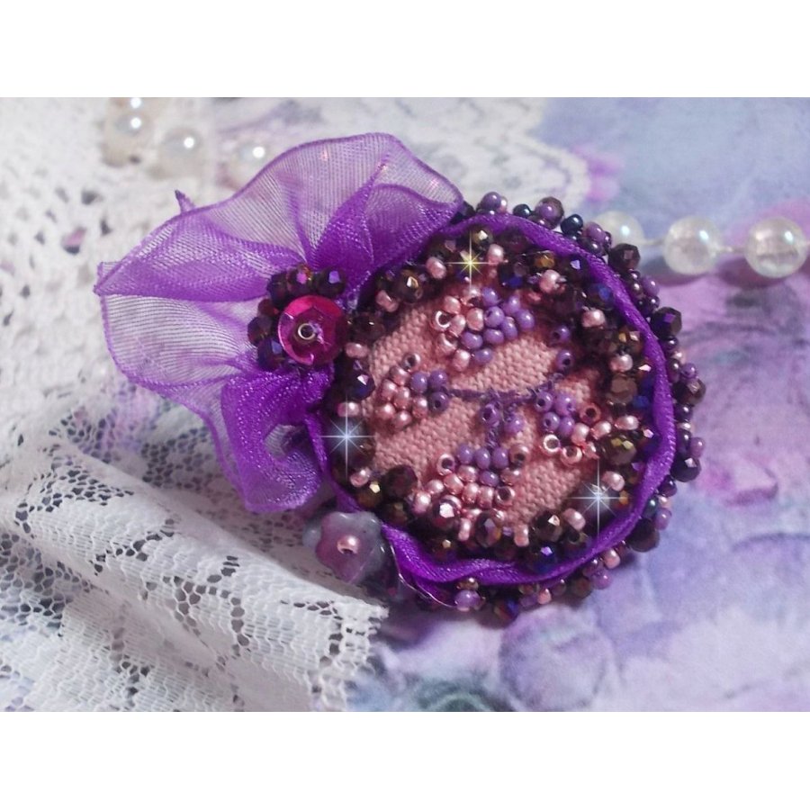 Romantisk Lady Ring broderad på ett rosa linnetyg med rosa, iris, lila och persika pärlor. 