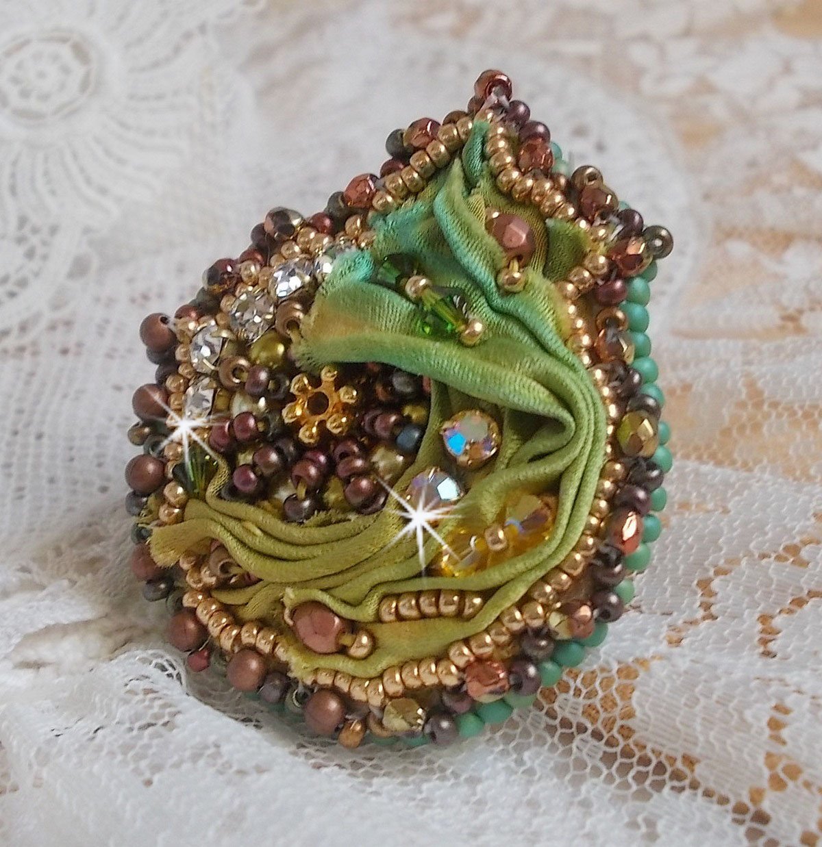 Venetiansk månring broderad med kameleonfärgat sidenband, Swarovskikristaller, olika pärlor och fröpärlor.