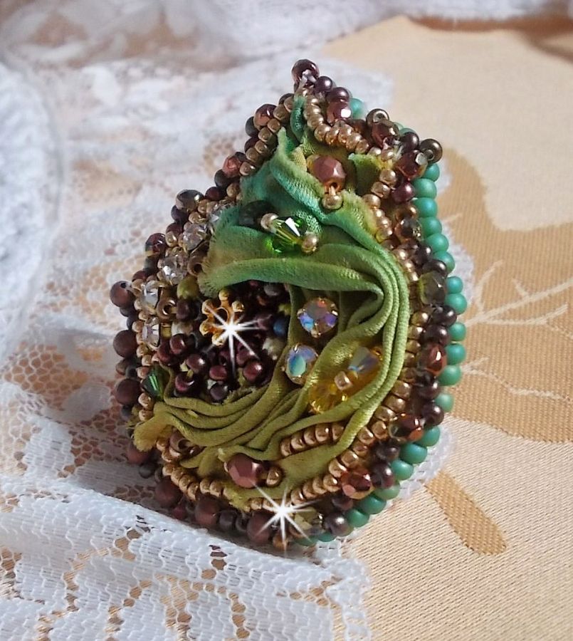 Venetiansk månring broderad med kameleonfärgat sidenband, Swarovskikristaller, olika pärlor och fröpärlor.