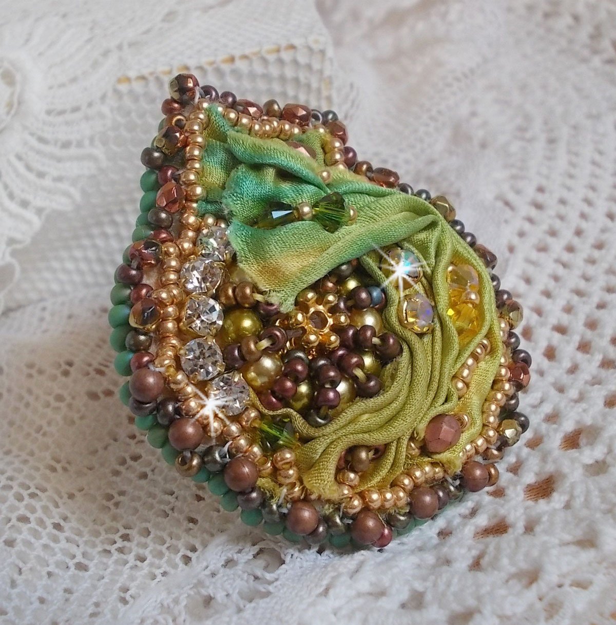 Venetiansk månring broderad med kameleonfärgat sidenband, Swarovskikristaller, olika pärlor och fröpärlor.