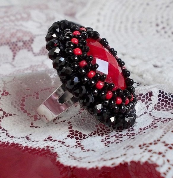 Midnight in Paris ring broderad med en röd facetterad cabochon och runda svarta pärlor.