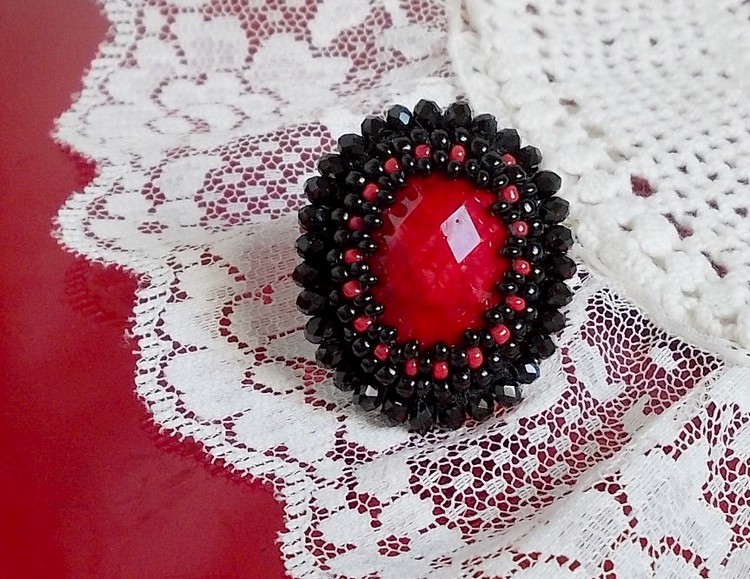 Midnight in Paris ring broderad med en röd facetterad cabochon och runda svarta pärlor.