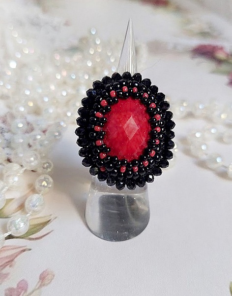 Midnight in Paris ring broderad med en r&ouml;d facetterad cabochon och runda svarta p&auml;rlor.