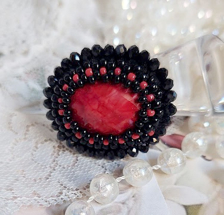 Midnight in Paris ring broderad med en röd facetterad cabochon och runda svarta pärlor.