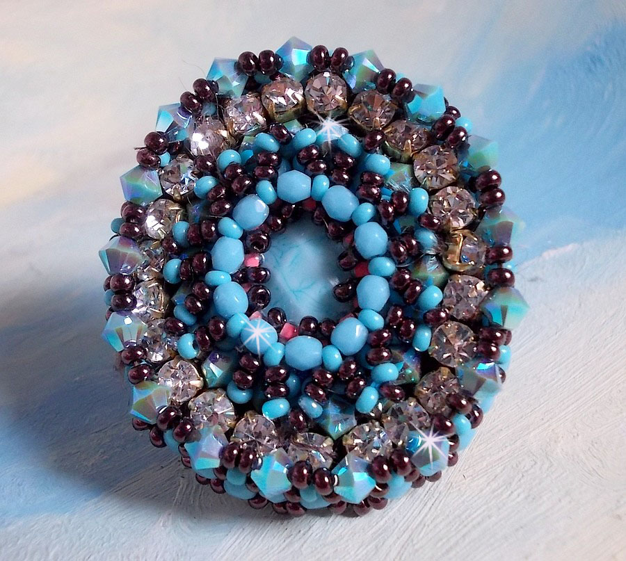 Naïade ring broderad med en turkosblå harts och kristallcabochon, ett vackert ljusspel.