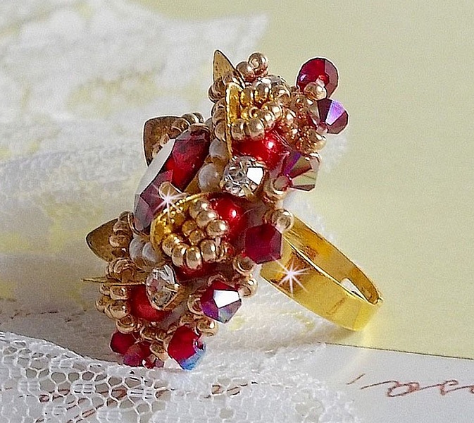 Ring L'Oiseau des Iles Rouge Dor&eacute; broderad med p&auml;rlor, Swarovskikristaller, ett vackert blomm&ouml;nster och fr&ouml;p&auml;rlor.
