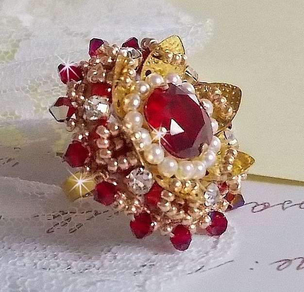 Ring L'Oiseau des Iles Rouge Dor&eacute; broderad med p&auml;rlor, Swarovskikristaller, ett vackert blomm&ouml;nster och fr&ouml;p&auml;rlor.