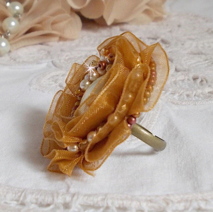 Reflets de Rosée-ring broderad med pärlor och ett Fauve-färgat organzaband.