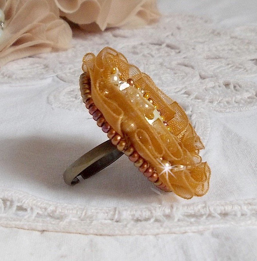 Reflets de Rosée-ring broderad med pärlor och ett Fauve-färgat organzaband.