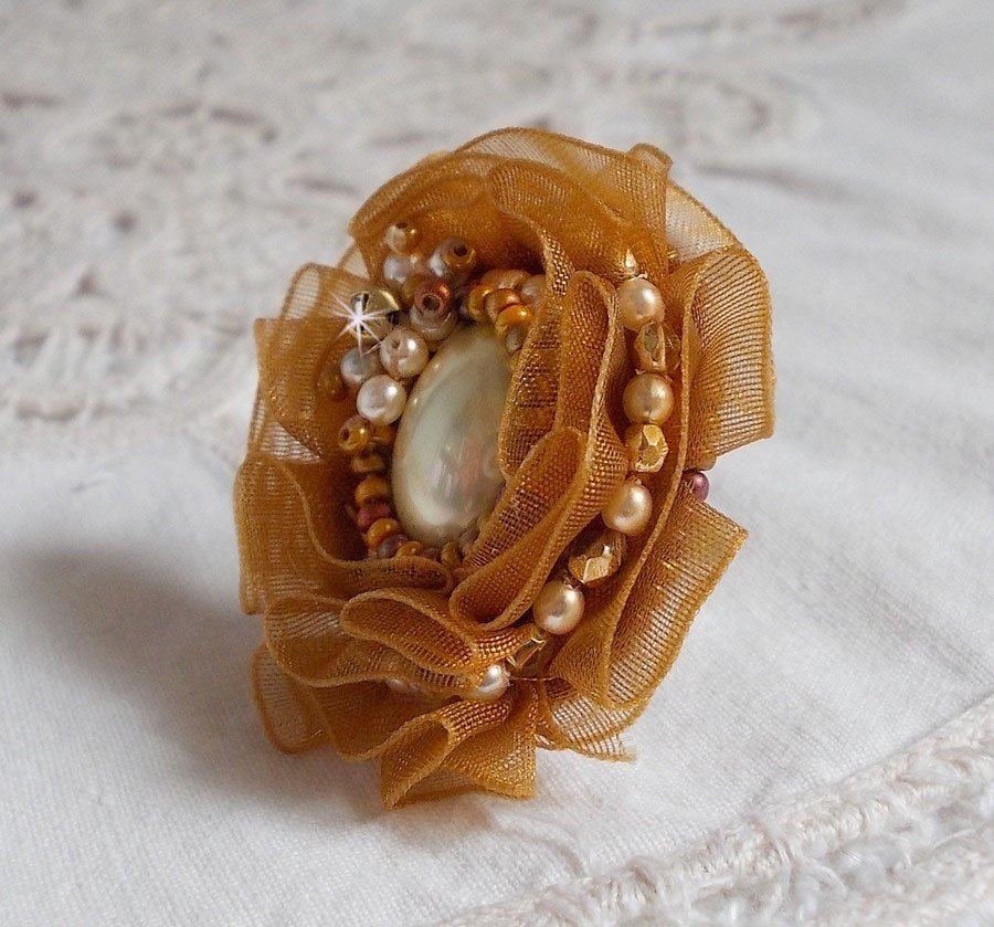Reflets de Rosée-ring broderad med pärlor och ett Fauve-färgat organzaband.