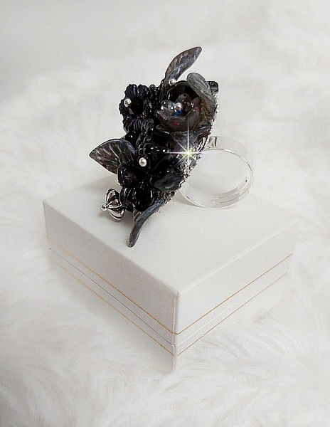 Bague Soir de Lune cr&eacute;&eacute;e avec des fleurs lucites Noires et Grises peintes &agrave; la main, cristaux, perles en r&eacute;sine, perles en verre et coupelle argent&eacute;e. Le tout est mont&eacute; sur une bague argent&eacute;e