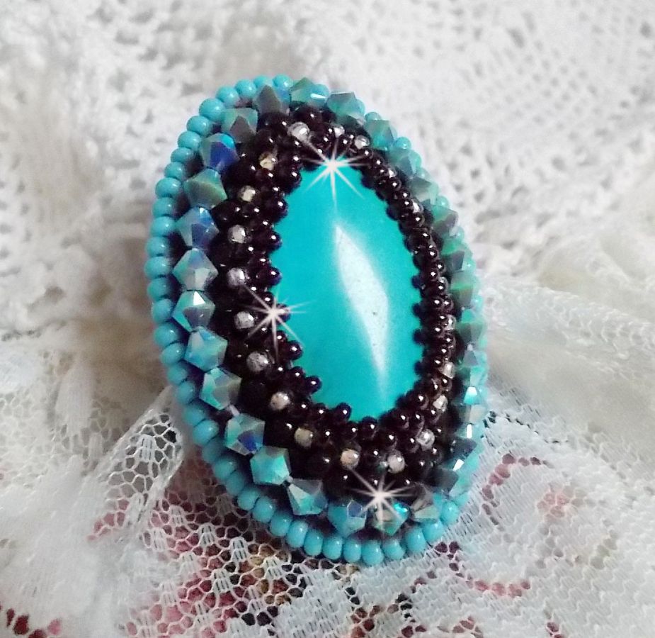 Turkos ring broderad med en turkos cabochon, PureCrystal spinnande toppar och fröpärlor.