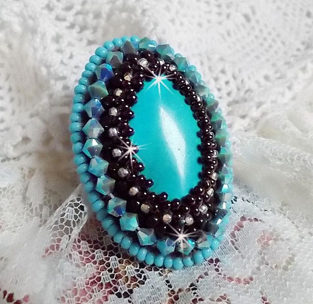 Turkos ring broderad med en turkos cabochon, PureCrystal spinnande toppar och fr&ouml;p&auml;rlor.