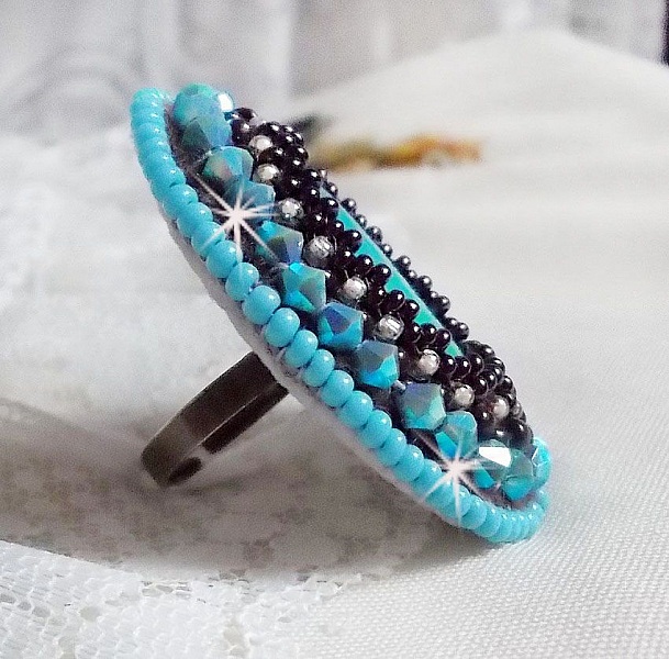 Turkos ring broderad med en turkos cabochon, PureCrystal spinnande toppar och fr&ouml;p&auml;rlor.