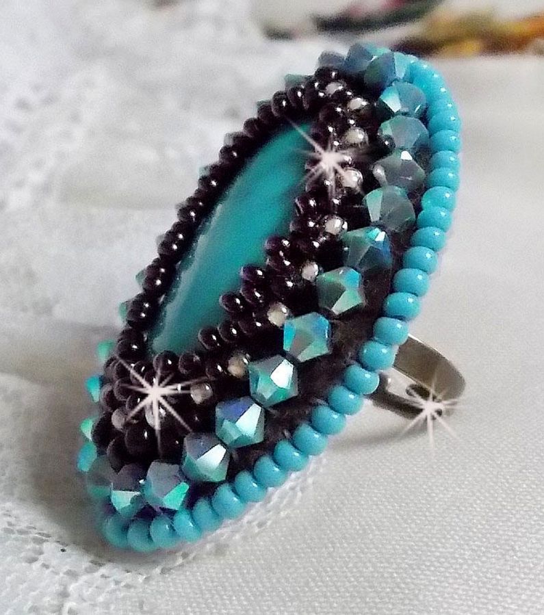 Turkos ring broderad med en turkos cabochon, PureCrystal spinnande toppar och fröpärlor.