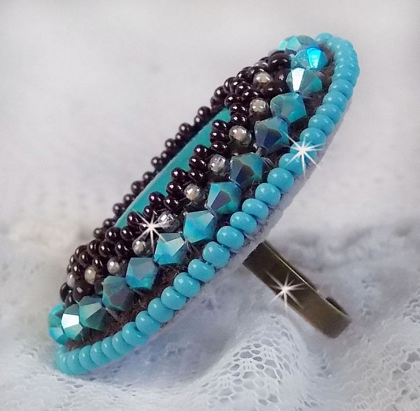 Turkos ring broderad med en turkos cabochon, PureCrystal spinnande toppar och fr&ouml;p&auml;rlor.
