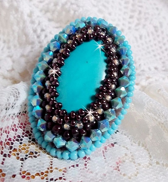 Turkos ring broderad med en turkos cabochon, PureCrystal spinnande toppar och fr&ouml;p&auml;rlor.