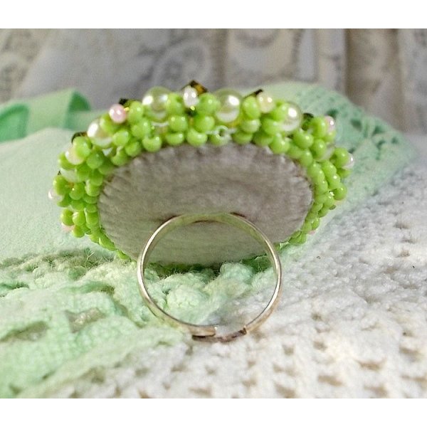 Anisse ring broderad med ett porträtt av en kvinna med rosor och Swarovskikristaller i cabochon av harts.