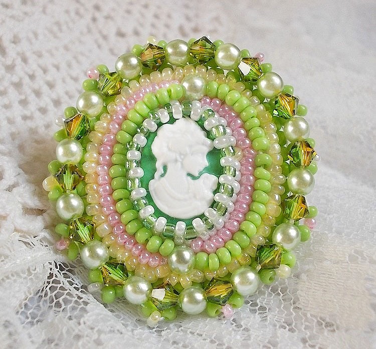 Anisse ring broderad med ett porträtt av en kvinna med rosor och Swarovskikristaller i cabochon av harts.