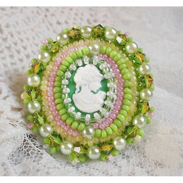 Anisse ring broderad med ett porträtt av en kvinna med rosor och Swarovskikristaller i cabochon av harts.