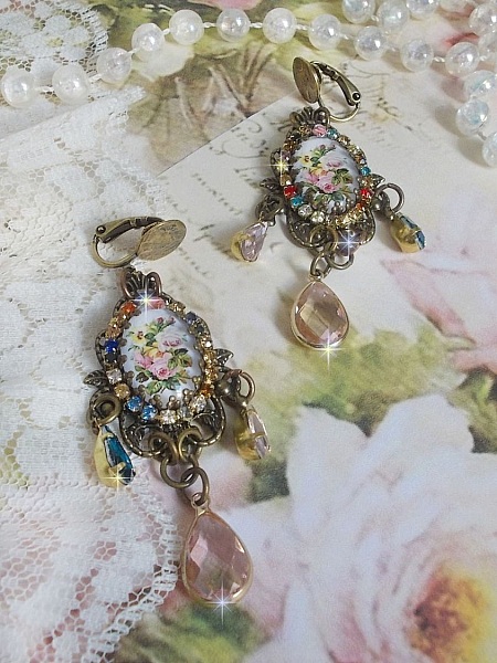 BO Affection of Roses skapad med glascabochoner som f&ouml;rest&auml;ller en bukett, glasp&auml;rlor, strass i olika f&auml;rger och m&auml;ssingstillbeh&ouml;r.