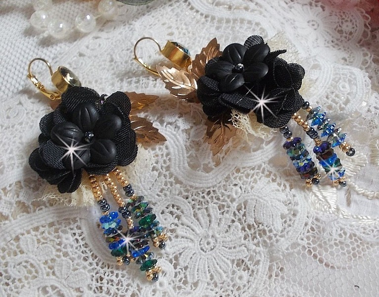 Boucles d'oreilles attrape-rêves artisanales noires et dorées avec fleurs.