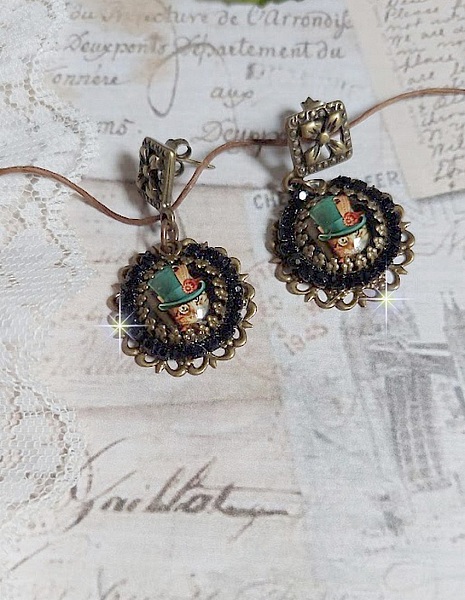 BO Chatou Steampunk mont&eacute;es avec cabochons loupes repr&eacute;sentant des chats en chapeau haut de forme Vert avec un m&eacute;daillon orn&eacute;s d&rsquo;une cha&icirc;ne strass Noire sur estampes Bonze et clous d'oreilles Laiton