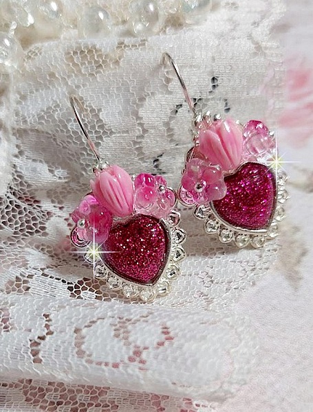 BO C&oelig;ur Ardent mont&eacute;es avec des dormeuses argent&eacute;es &agrave; laquelle s&rsquo;ajoute des c&oelig;urs paillet&eacute;s en r&eacute;sine Fuchsia. Ils sont orn&eacute;s d&rsquo;un bouquet de fleurs en verre &agrave; la couleur Rose pour un style romantique