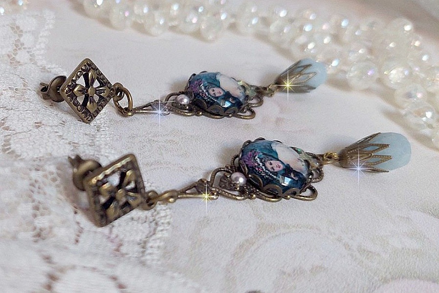 BO Dame au chapeau fleuri repr&eacute;sentant une femme au chapeau entour&eacute; d&rsquo;un ruban noir est mont&eacute; sur des estampes avec des n&oelig;uds en cristal. Une belle &eacute;l&eacute;gance avec ces gouttes en Jade teint&eacute;es de Bleu