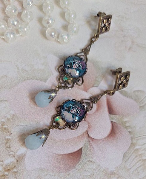 BO Dame au chapeau fleuri repr&eacute;sentant une femme au chapeau entour&eacute; d&rsquo;un ruban noir est mont&eacute; sur des estampes avec des n&oelig;uds en cristal. Une belle &eacute;l&eacute;gance avec ces gouttes en Jade teint&eacute;es de Bleu