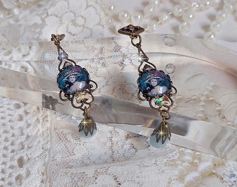 BO Dame au chapeau fleuri repr&eacute;sentant une femme au chapeau entour&eacute; d&rsquo;un ruban noir est mont&eacute; sur des estampes avec des n&oelig;uds en cristal. Une belle &eacute;l&eacute;gance avec ces gouttes en Jade teint&eacute;es de Bleu