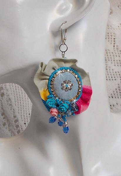 BO Far West broderad med denimtyg, rosor av harts, Swarovski-kristaller, olika p&auml;rlor, fr&ouml;p&auml;rlor och silverp&auml;rlor i 925/1000 och andra p&auml;rlor.