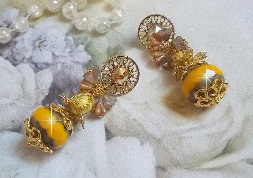 BO Lumi&egrave;re Opale Jaune avec des perles potirons jaunes &agrave; laquelle s&rsquo;ajoute des fleurs, cabochons en cristal, coupelles et perles rondes. Mont&eacute;s sur clous d&rsquo;oreilles en M&eacute;tal. Un style moderne