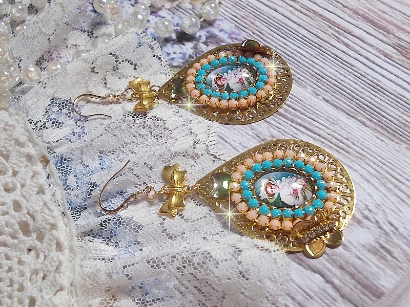 BO Mademoiselle Noellia avec des cabochons ovales repr&eacute;sentant une femme avec un chapeau et un n&oelig;ud blanc &agrave; laquelle s&rsquo;ajoute des cristaux, cha&icirc;nes strass P&ecirc;che et Turquoise sur crochets en plaqu&eacute; Or