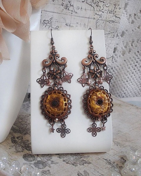 BO Myst&egrave;res d'Ars&egrave;ne skapad med olika formade berlocker, h&auml;ngande medaljonger, patinerade porslinsmotiv och Swarovski-kristaller.