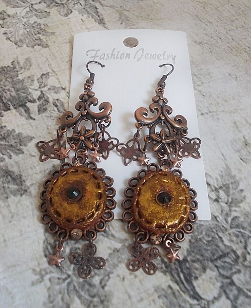 BO Myst&egrave;res d'Ars&egrave;ne skapad med olika formade berlocker, h&auml;ngande medaljonger, patinerade porslinsmotiv och Swarovski-kristaller.