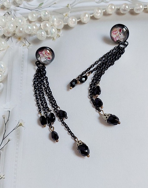 Boucles d'oreilles bohèmes noires avec chaînes et perles facettées.