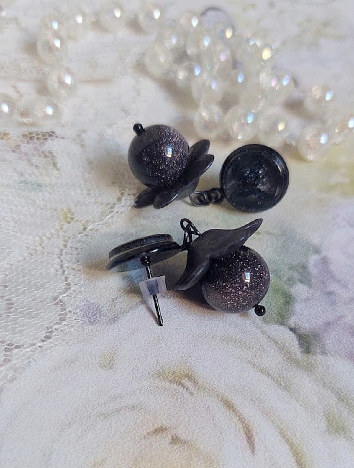 Boucles d'oreilles puces artisanales avec fleurs et perles scintillantes.