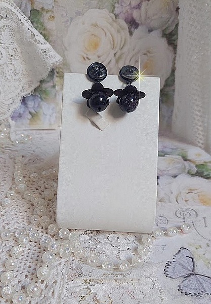 Boucles d'oreilles pépites avec fleurs noires et perles scintillantes.