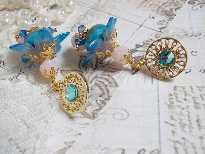 Boucles d'oreilles pendantes fleurs bleues, perles roses et cristaux.