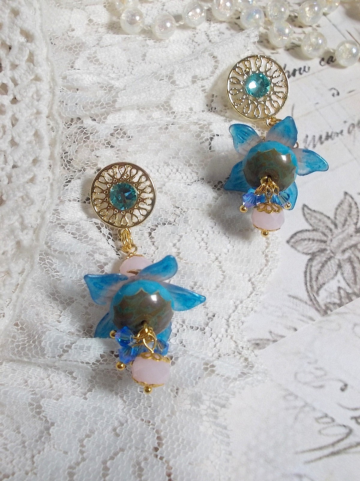 Boucles d'oreilles pendantes fleurs bleues et perles Swarovski dorées.