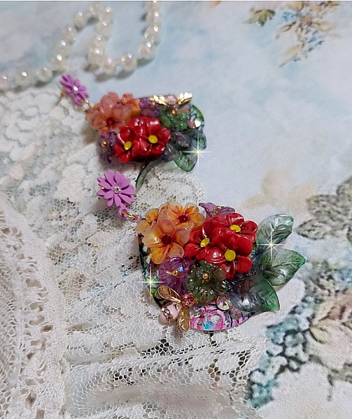 Boucles d'oreilles artisanales fleuries avec abeilles et cristaux colorés.