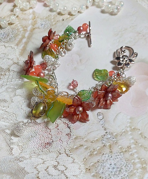 Bracelet gourmette argenté avec fleurs, feuilles et jade orange.